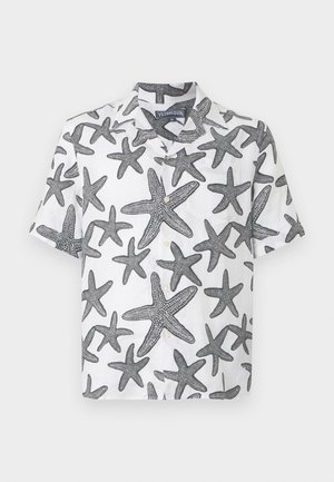 Balta īsām piedurknēm krekls ar melnu zvaigžņu zīmējumu. Pogājams priekšpusē un apkakles dizains. Viegls lins.