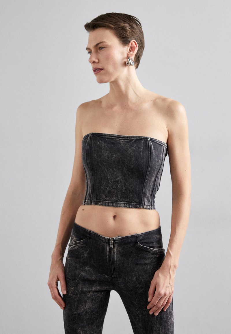 Black denim strapless crop top with faded texture and structured seams, paired with matching high-waisted jeans featuring a zipper closure.