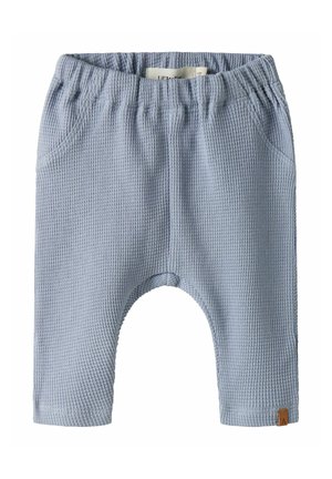 Light blue baby pants with waffle texture, elastic waistband, side pockets, and small brown tag on the bottom right leg.