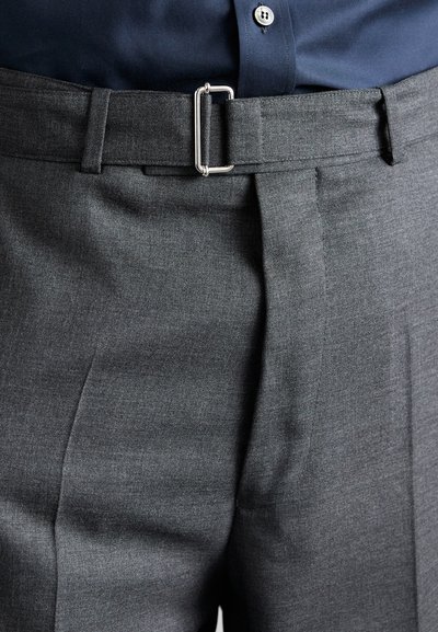 Pantalons gris ajustés avec un devant plat, des plis nets et une ceinture à boucle rectangulaire en argent, mettant en valeur une texture lisse et un tissu tissé.