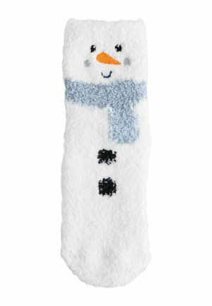 White fuzzy sock with a snowman design, featuring a blue scarf, orange carrot nose, black buttons, and stitched facial details.