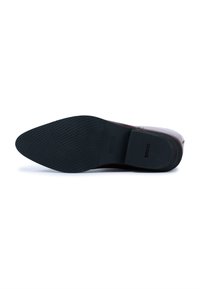 Semelle noire d'une chaussure avec une finition en caoutchouc texturé, accompagnée d'une partie supérieure bordeaux. La chaussure a un léger talon et aucune ornementation visible.