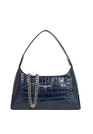 Sac à main en cuir bleu foncé texturé crocodile avec détail chaîne argentée et une seule anse, marqué "Lancaster Paris" à l'avant.