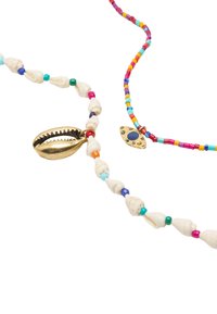 Dwa naszyjniki: jeden z małymi kolorowymi koralikami i białymi muszlami, drugi z złotą muszlą i dekoracyjnym wisiorkiem w kształcie oka.