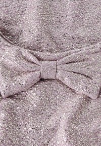 Tessuto lavanda con superficie testurizzata caratterizzato da paillettes e glitter argentati, accentuato da un grande fiocco al centro.