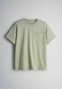 Lichtgroen katoenen T-shirt met korte mouwen, een ronde hals en een zakje op de linkerborst, getoond tegen een effen achtergrond.