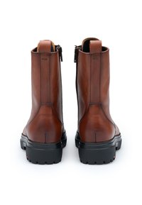 Bruine leren enkellaarzen met een gestructureerd oppervlak, zwarte rubberen zolen en ritssluitingen aan de zijkanten. Achteraanzicht toont de gladde afwerking en de stiksel details.