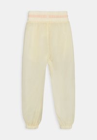 Helles Gelb, durchsichtige Jogginghosen mit einem elastischen Bund und einem zarten rosa Akzent. Mit umschlagenen Säumen und einer lockeren Passform bieten sie lässigen Komfort.