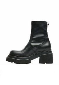 Stivale alla caviglia in pelle nera con suola in gomma chunky, dotato di punta arrotondata e pannelli laterali elastici per una facile calzata. Design complessivo elegante.