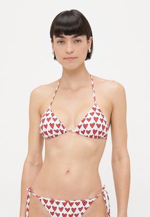 Red heart-patterned bikini set with a triangular top and adjustable ties on the sides, made from lightweight fabric in white and red colors.