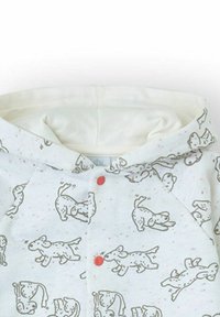 Sudadera con capucha blanca para bebé con ilustraciones divertidas de perros y dos botones a presión rojos en la parte delantera.