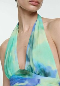 Halter neck dress in lightweight fabric, featuring a gradient of green and blue tie-dye; deep neckline and soft pleats at the waist.