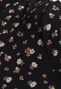 Schwarzer gerippter Stoff mit einem Blumenmuster in Creme, Braun und Grün. Enthält kleine, verstreute Blumen auf der Oberfläche.