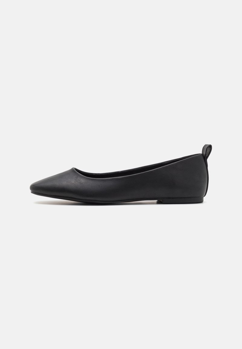 Sapatilha de balé em couro preto com bico apontado, sola achatada e uma pequena aba no calcanhar para facilitar o calçar. Textura suave, design minimalista.