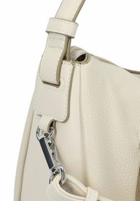 Sac à main en cuir beige avec une surface texturée, doté d'un clip en métal et d'une bandoulière réglable, d'accents lisses et de détails de couture renforcée.