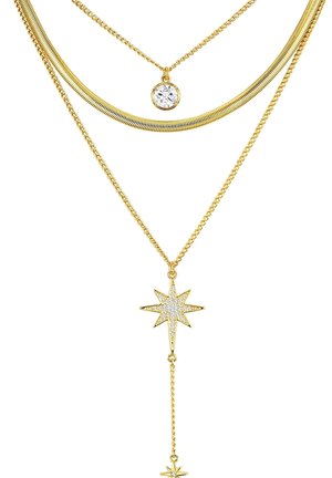 Collana a più strati in tono dorato con una catena a serpente liscia, un pendente rotondo in cristallo e un ciondolo a stella con design testurizzato e piccoli cristalli.
