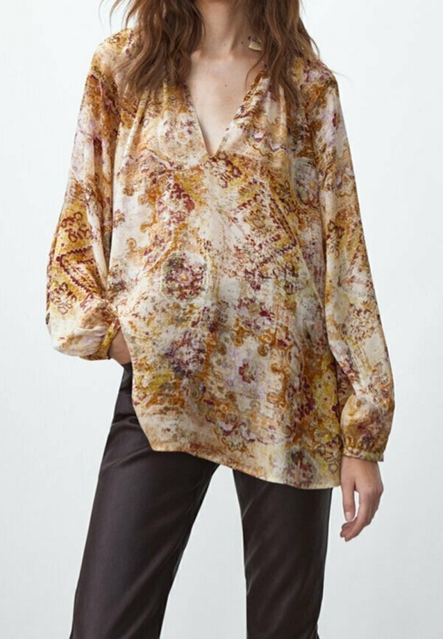 Blouse à manches longues et col en V en tissu léger, présentant un motif abstrait coloré avec des nuances de crème, orange et marron. Poignets réglables.