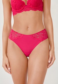 Różowe koronkowe figi w kolorze fuksji z gładkiego materiału, ozdobione kwiatową koronką po bokach, o klasycznym kroju i miękkiej fakturze.