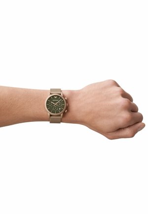 Runde olivgrüne Uhr an einem Mesh-Armband, mit goldfarbenen Hardware-Elementen und einem strukturierten Zifferblatt mit weißen Stundenmarkierungen und Unterzifferblättern.