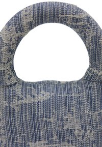 En blå og beige mønstret stofpose med et rundt håndtag, der har et struktureret, vævet design. Materialet virker robust og fleksibelt.