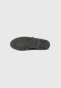 Czarna gumowa podeszwa buta z głębokim bieżnikiem zapewniającym przyczepność. Posiada wytłoczone logo Timberland oraz trwałą, teksturowaną powierzchnię dla lepszego chwytu.