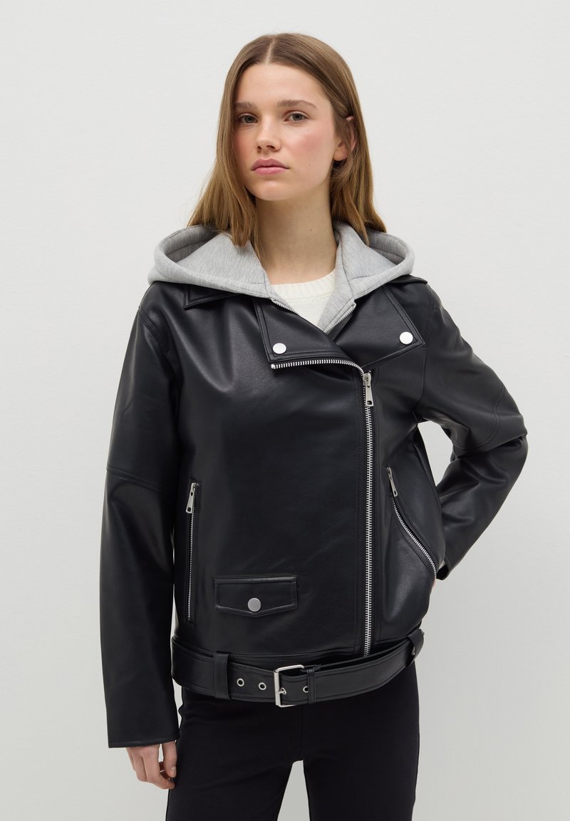 Veste de moto en cuir noir avec capuche grise, zips en argent et boutons pression. Présente une taille ceinturée et des poches latérales. Texture lisse.