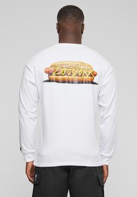 White long-sleeve t-shirt featuring a graphic of a hot dog with yellow mustard and sauerkraut, text "ZOYORK" in yellow.