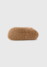 Brauner Gummisohlen mit einem strukturierten Grip-Muster, ausgestattet mit tiefen Rillen und einem eingepraegten Logo. Entworfen für Traktion und Langlebigkeit.