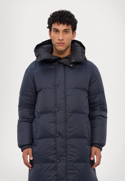 Donsjas in donker marineblauw, met een doorgestikt ontwerp, hoge kraag, capuchon, drukknoopsluiting en elastische manchetten voor warmte en comfort.