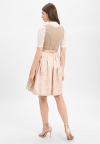 Kleid mit einem enganliegenden beigefarbenen Oberteil, kurzen Spitzenärmeln und einem ausgestellten rosa Rock mit floralem Muster. Inklusive eines Satinbands in der Taille.