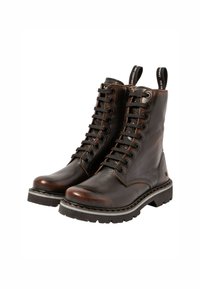 Bottes en cuir marron à lacets avec une semelle en caoutchouc épaisse, dotées d'œillets en métal, de coutures contrastées et de languettes en boucle sur la tige.