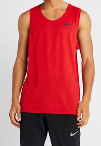 Rød Nike ærmeløs tanktop lavet af letvægtsmateriale. Har rund halsudskæring og et lille sort logo på brystet.