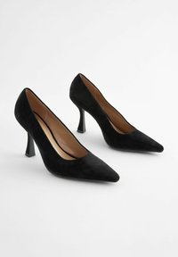 Czarne zamszowe szpilki z ostro zakończonym noskiem, smukłym obcasem typu stiletto i gładkim wewnętrznym wykończeniem. Jednolity kolor, bez dodatkowych wzorów czy akcentów.