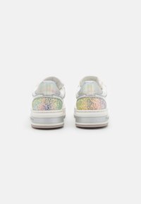 Weiße Sneakers mit einem strukturierten, mehrfarbigen Glitzerspitze und silberner Akzentuierung. Glattes Obermaterial und gepolsterte Zunge. Minimalistisches Design.