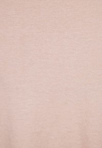 Ljusrosa bomullstyg med en jämn, texturerad yta, som har ett konsekvent, subtilt stickat m önster genom hela tyget.