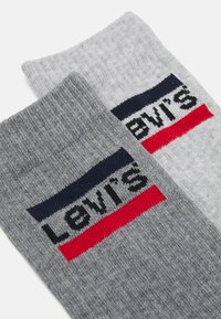Grå bomuldsstrømper med et ribbet design og et logo-bånd med navy, rød og sort stribe, der står "LEVI'S" på toppen.