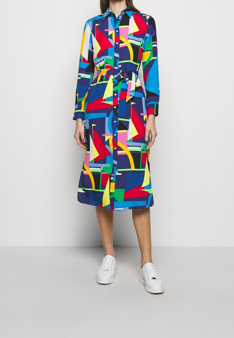 Knapp-up skjortklänning med ett färgglatt geometriskt mönster i blått, rött, gult och grönt, med midjeband och långa ärmar.