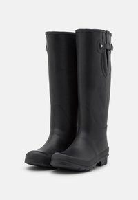 Bottes en caoutchouc noires, hautes jusqu'au genou, avec une finition lisse, un bout arrondi, un détail de sangle réglable sur le côté et une semelle texturée pour l'adhérence.