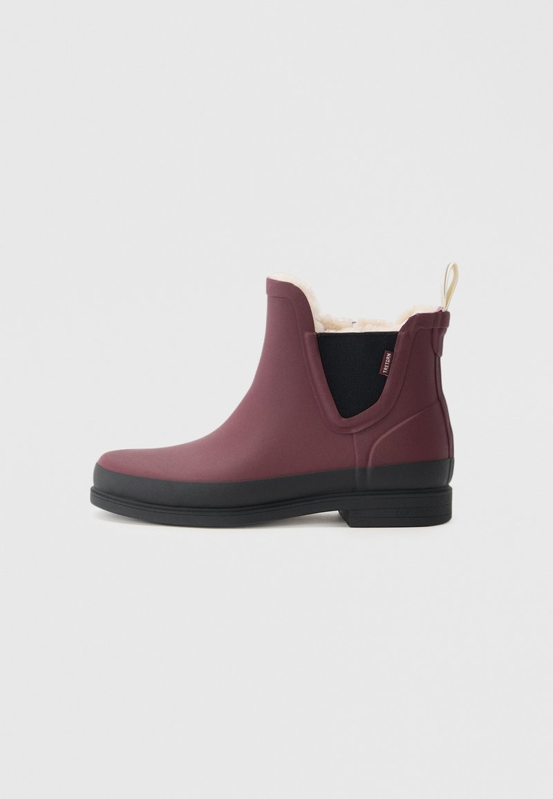 Bottes de cheville imperméables bordeaux avec une semelle noire, dotées d'une doublure en fourrure douce, de panneaux latéraux élastiques et d'une languette à l'arrière.