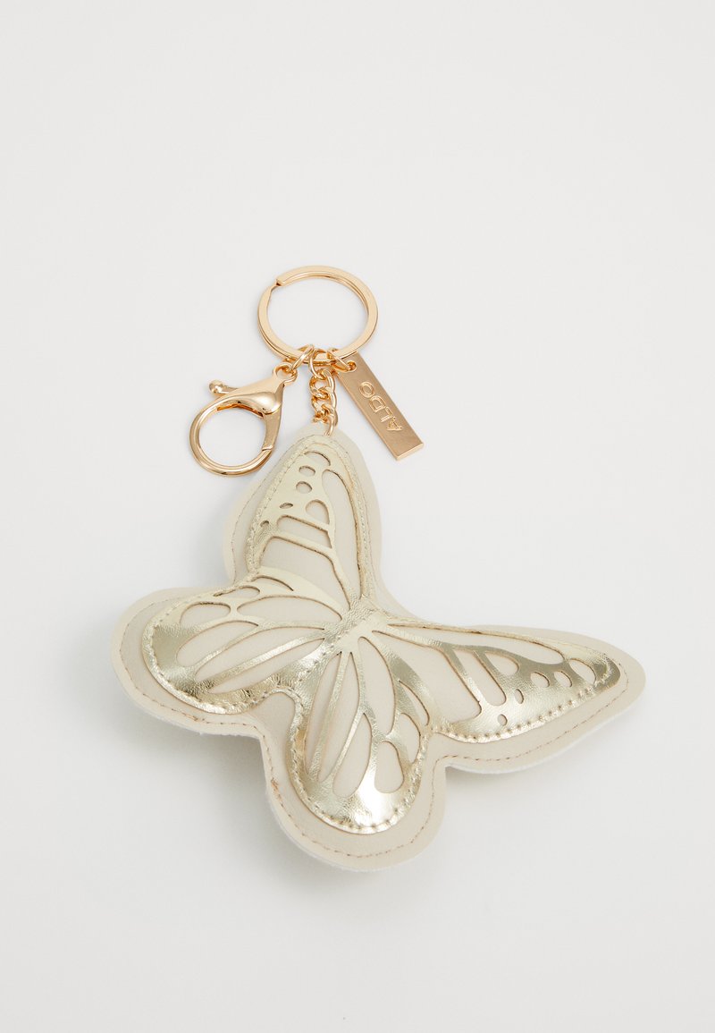 Portachiavi a forma di farfalla realizzato in pelle color crema con dettagli metallici dorati e ali intagliate; attaccato a un anello portachiavi in tono dorato.