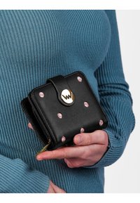 Black leather wallet with pink dotted pattern, gold hardware, and a snap closure. Compact square shape, featuring a zippered compartment.