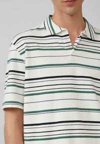 Gestreepte polo in het wit, met horizontale strepen in groen, marineblauw en paars. Gemaakt van een gestructureerde stof met een klassieke kraag en korte mouwen.