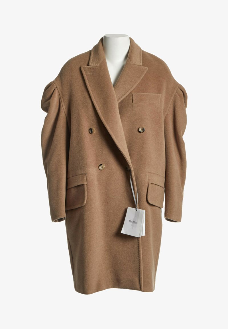 Manteau en laine marron croisé avec larges revers, épaules structurées, deux poches avant à rabat et une petite poche poitrine sur un mannequin blanc.