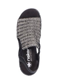 Sandale noire avec une sangle tissée comportant des accents blancs, réglable sur le côté, semelle texturée et semelle en caoutchouc. Logo de la marque visible.