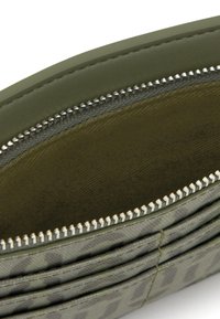 Cartera verde oliva con superficie texturizada, cierre con cremallera y ranuras para tarjetas, con un sutil patrón de estampado animal en el interior.