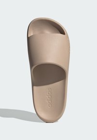 Beige slide sandal med bred öppning och texturerad innersula. Tillverkad av slät, slitstark material, med det präglade varumärkeslogotypen.