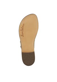 Sola di sandalo piatta in pelle beige con tacco in gomma testurizzata marrone chiaro. Presenta un contorno cucito e la firma "Sam Edelman" in rosso.