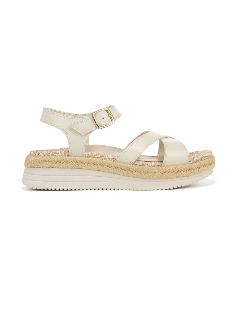 Beige platform sandal with crossover strap design, adjustable ankle buckle, and woven jute midsole. Textured rubber outsole for grip.