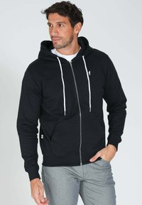 Hoodie noir à fermeture éclair en mélange de coton, avec des cordons de serrage blancs, des poches avant et un petit logo sur la poitrine gauche.