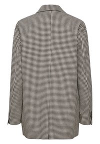 Motif pied-de-poule, noir et blanc, blazer déstructuré, simple boutonnage, manches longues, col cranté, deux boutons aux poignets.